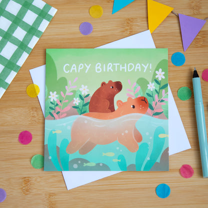 A photograph of a birthday card featuring cute capybaras, the card reads "Capy Birthday!".