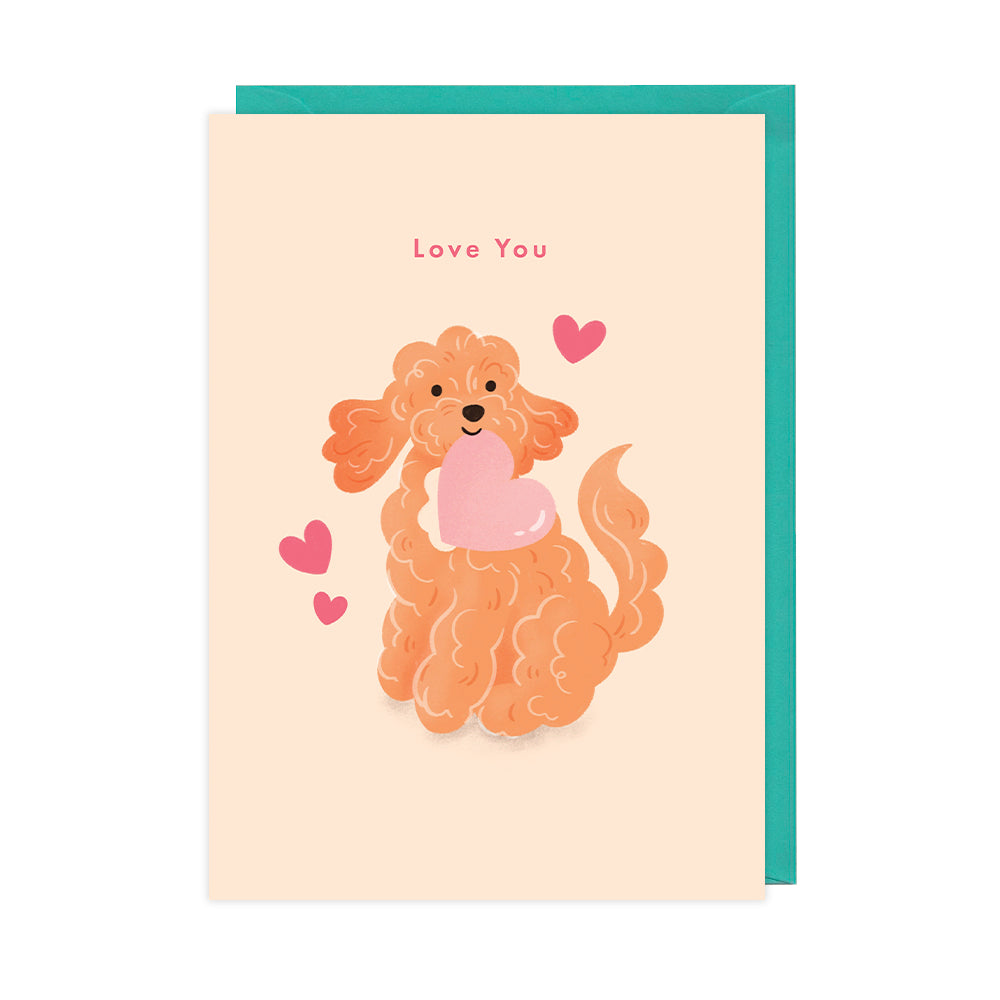 A greetings card of a happy fluffy dog holding a cute heart that reads "love you". 