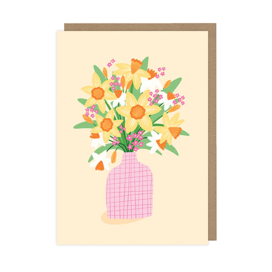 A blank greetings card featuring a vase with daffodils on a yellow background. 