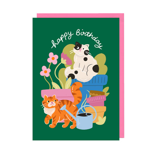 A green birthday card featuring two cats playing in a garden. 