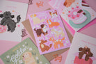 A photograph of a collection of dog-themed birthday cards on a pink background.