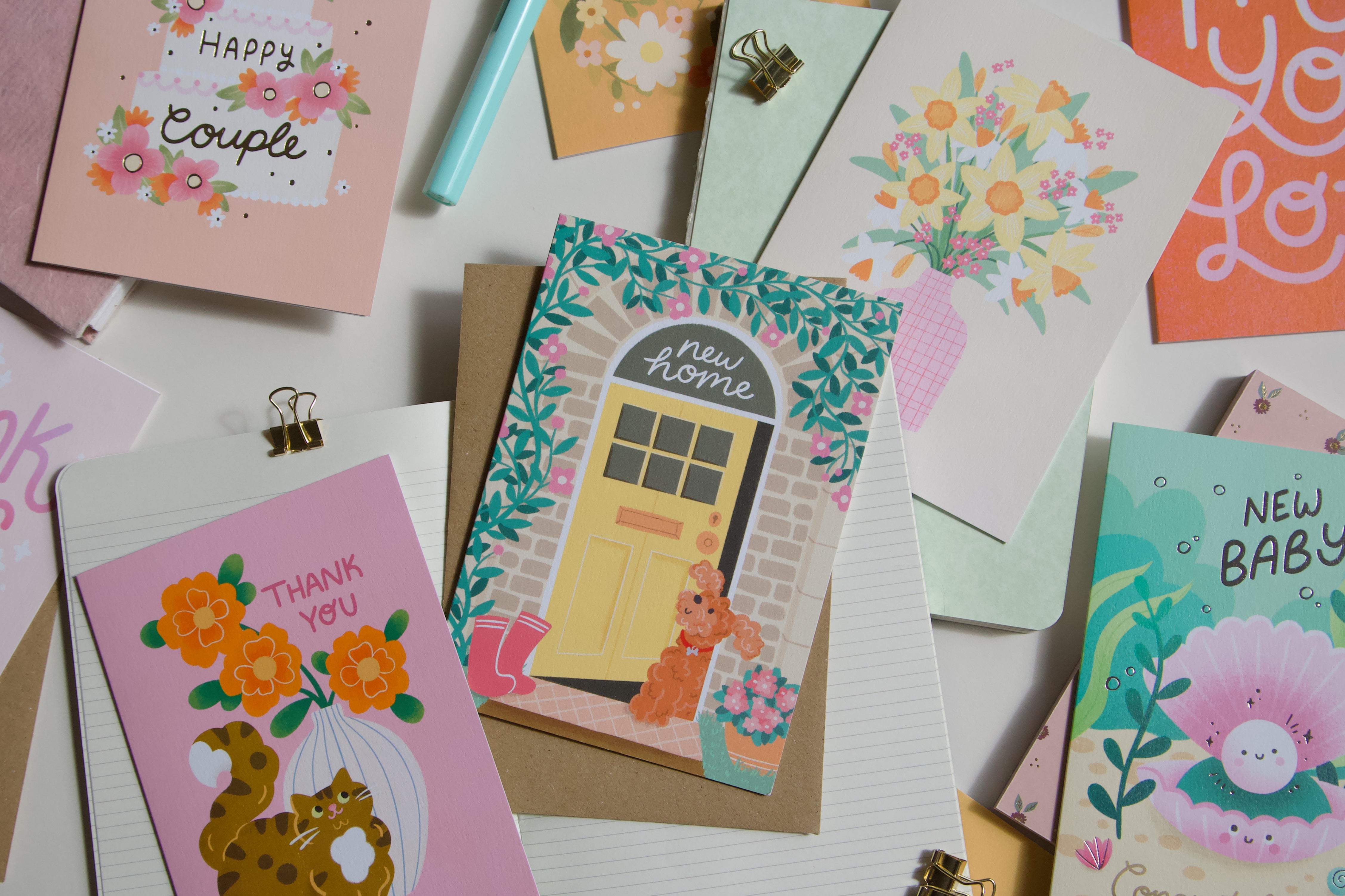 A photograph of a collection of cards featuring a cockapoo dog new home card. 