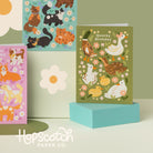 Three colorful greeting cards with animal illustrations on a light green background, featuring the brand 'HopScotch Paper Co.'.